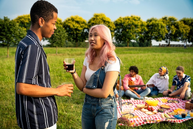 Group of multiethnic teenagers spending time outdoor on a picnic at the park