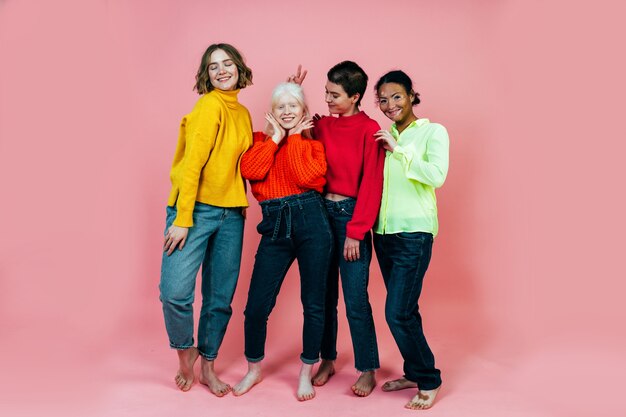 Gruppo di donne multietniche con diversi tipi di pelle che posano insieme in studio concetto sul corpo ...