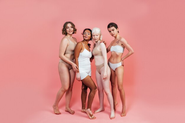 group of multiethnic women with different kind of skin posing together in studio