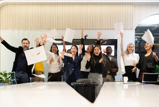 A group of multiracial businesspeople throwing paper to celebrate success