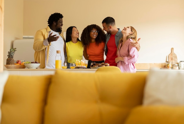 Group of multiracial friends celebrating birthday at home kitchen