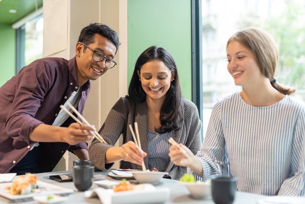 日本食レストラン世代の多民族の友人のグループzの人々は昼食時に楽しんでいます