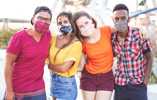 Gruppo di amici multirazziali che scattano foto con maschera facciale su - giovani che si divertono in vacanza - nuovo concetto di stile di vita