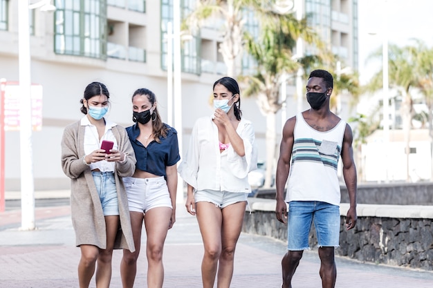 Group of multiracial friends walking together in city