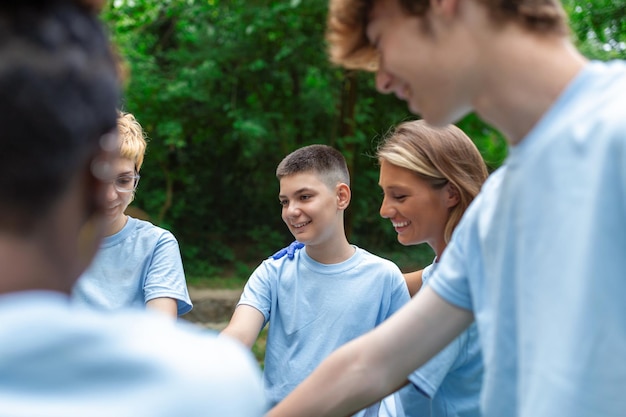 Group of multiracial volontaire young people building team\
outdoor in park join hands together