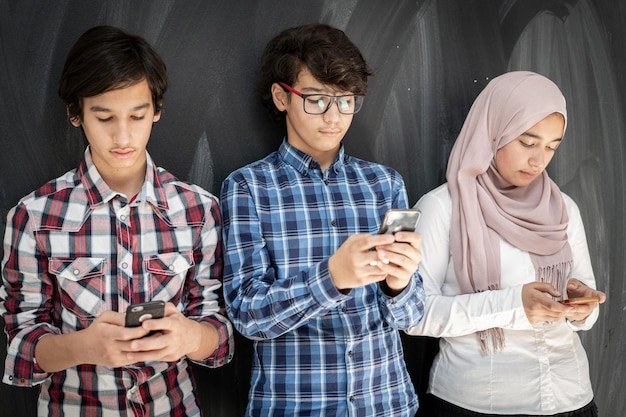 Group of multy ethnic kids in classroom with smartphones