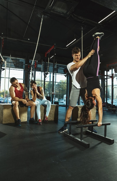 A group of muscular athletes doing workout at the gym Gymnastics training fitness workout