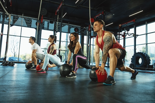 Un gruppo di atleti muscolosi che si allenano in palestra fitness training ginnico