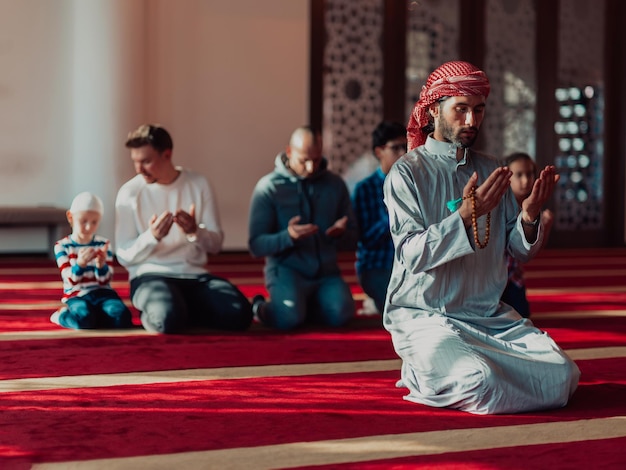 Группа мусульман в современной мечети совершает мусульманский намаз во время священного месяца Рамадан.