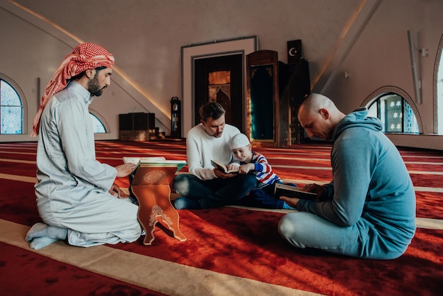 Группа мусульман читает священную книгу Коран в современной мечети во время мусульманского праздника Рамадан.