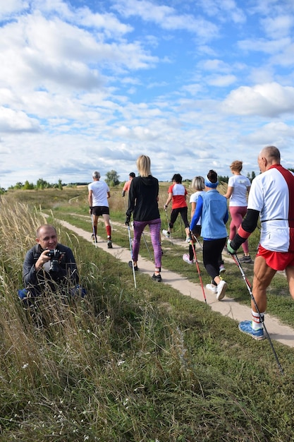 A group of Nordic walking athletes pass a photographer at a competition