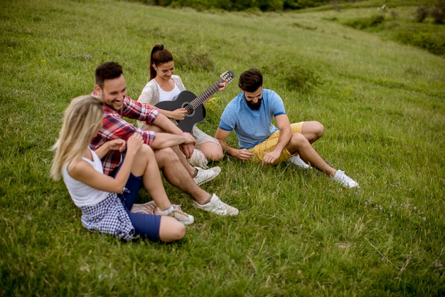 group od young people having fun on a field trip in nature on a mountain