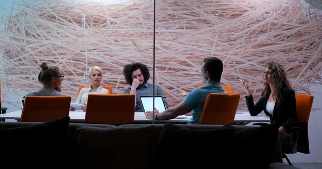 Фото Группа молодых деловых людей, обсуждая бизнес-план в современном стартап-офисном здании
