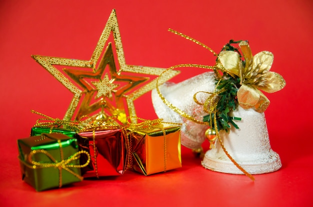 Фото Группа колокол, подарок и звезда в рождество на красном фоне