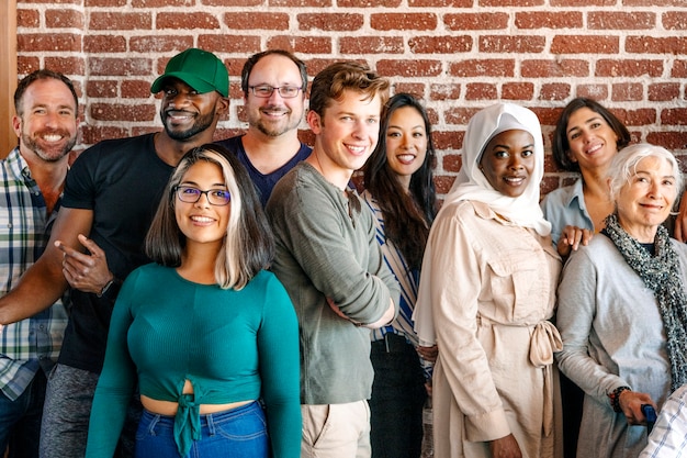 Фото Группа разнообразных людей, стоящих перед кирпичной стеной