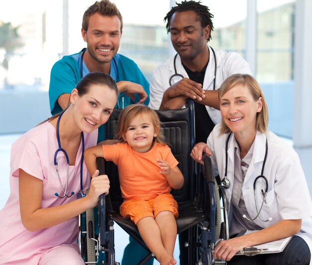 写真 車椅子で赤ちゃんと医者のグループ