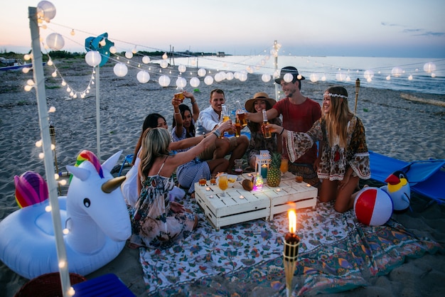 사진 일몰 시간에 해변에서 파티를 만드는 친구의 그룹