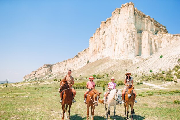 写真 明るい空に向かって馬に乗る人々のグループ