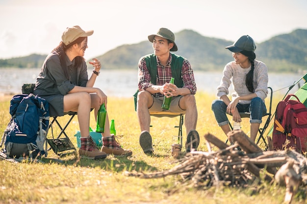 写真 キャンプでビール瓶をチリンと鳴らす観光客のグループ。冒険、旅行、観光、友情と人々の概念。