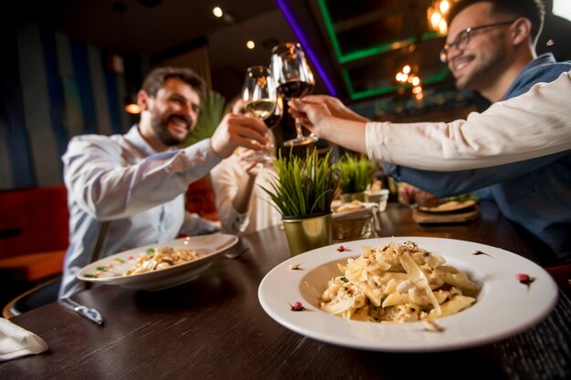 レストランで夕食を食べている若い人たちのグループ