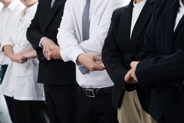 Group of office workers holding hand in line to promote harmony in workplace