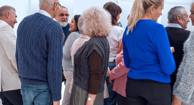 A group of old people standing with their backs indoors