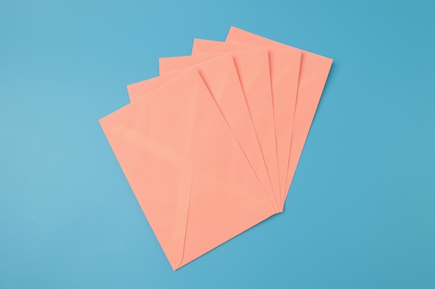 Group of orange envelopes in a row isolated on a blue background