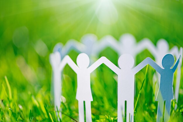 Photo group of paper people holding hands together. concept of social help in group. team concept