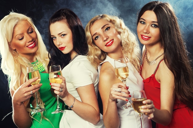 Group of partying girls clinking flutes with sparkling wine