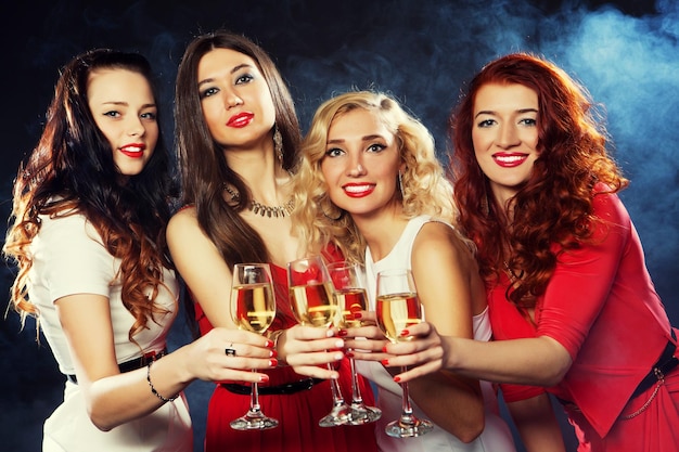 Group of partying girls clinking flutes with sparkling wine