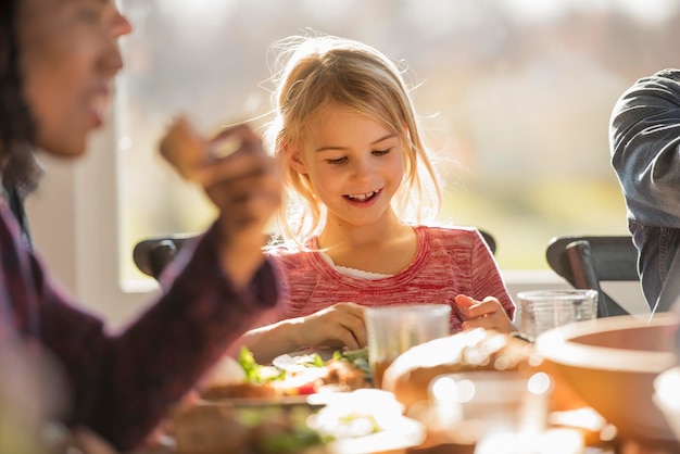 Photo a group of people adults and children seated around a table for a meal