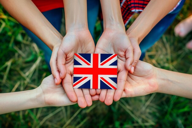 A group of people are making a gesture with a small British flag in their hands