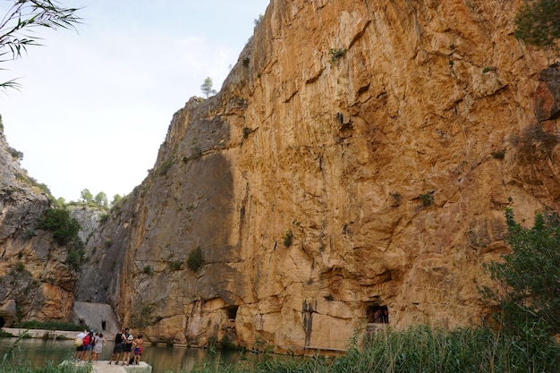 A group of people are standing in front of a cliff, one of which is called the river elbe.