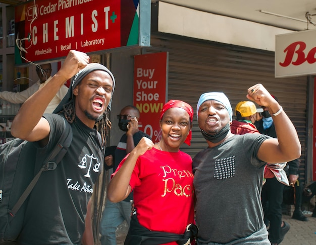 a group of people are standing outside of a store with a red sign that says  pop - up