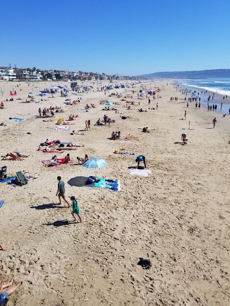 Group of people on beach against clear sky