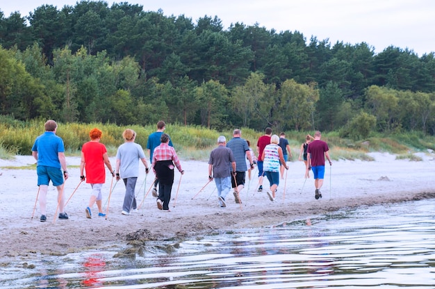 A group of people on the beach are engaged in sports