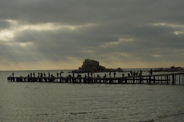 Group of people on beach by sea against sky