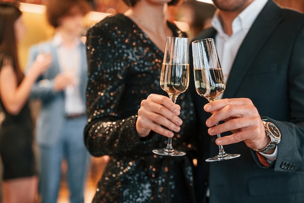 Photo group of people in beautiful elegant clothes are celebrating new year indoors together