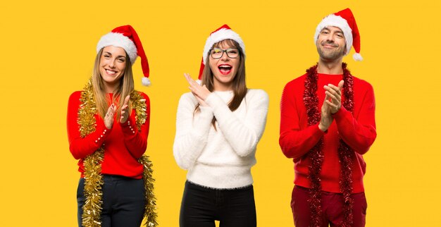 A group of people Blonde woman dressed up for christmas holidays applauding 