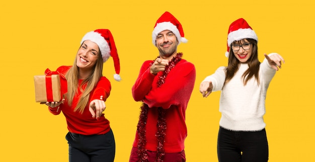 A group of people Blonde woman dressed up for christmas holidays points finger at you