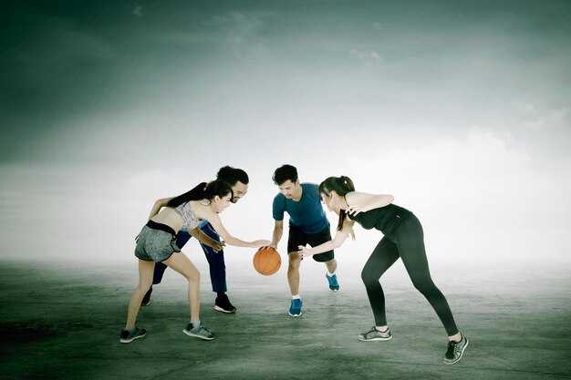 Group of people bouncing a basketball while training