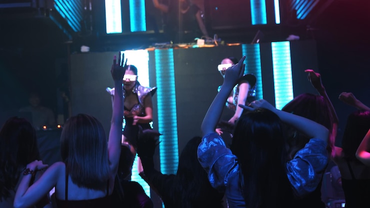 Photo 人々のグループがステージ上のdjからの音楽のビートに合わせてディスコナイトクラブで踊ります