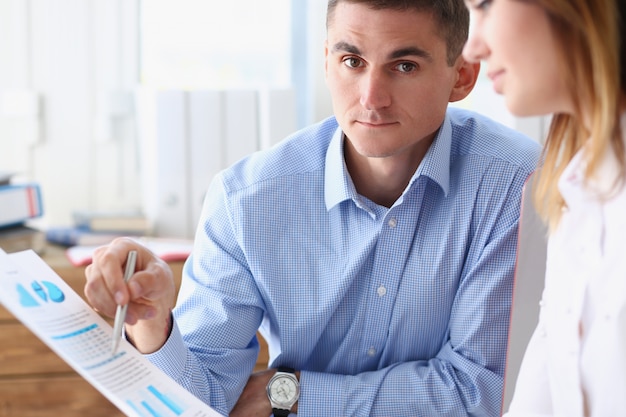 Group of people deliberate on problem with paper