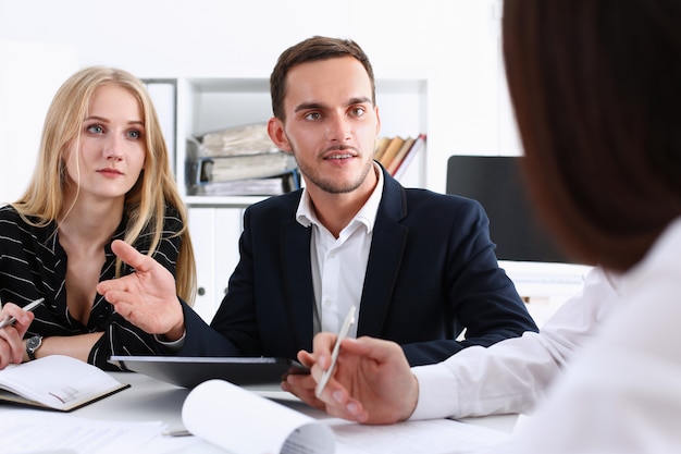 Group of people deliberate on white board