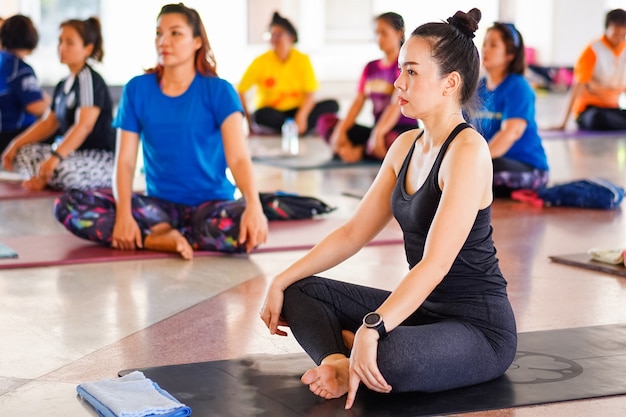 Photo group of people doing yoga training in yoga class in the indoor gymnasium to relax and get healthy health. sport and recreation stock photo