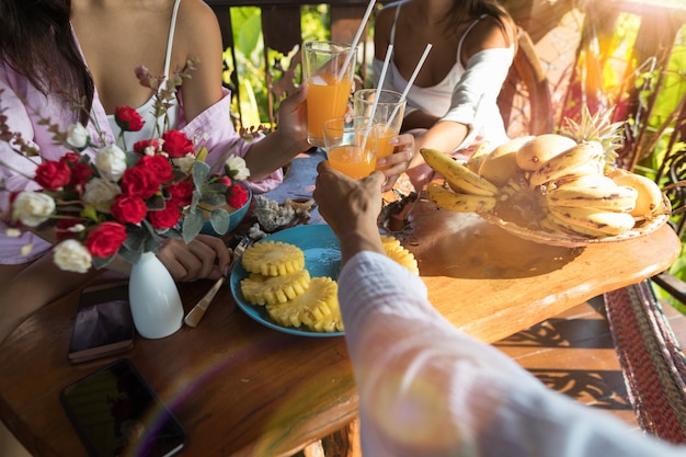 Group Of People Eating Breakfast Together Cheering Glasses 