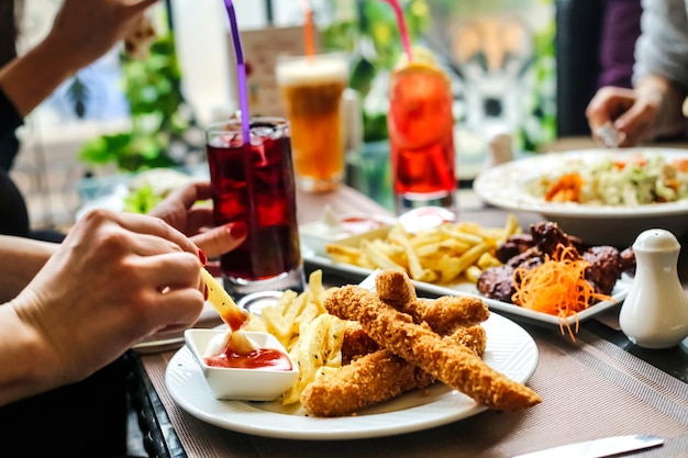テーブルの周りで食べ物を食べている人々のグループ