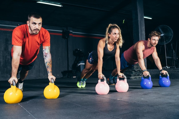 Group of people exercising with kettlebells in a gym