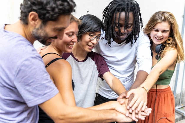 Photo group of people from different ethnic groups putting their hand together