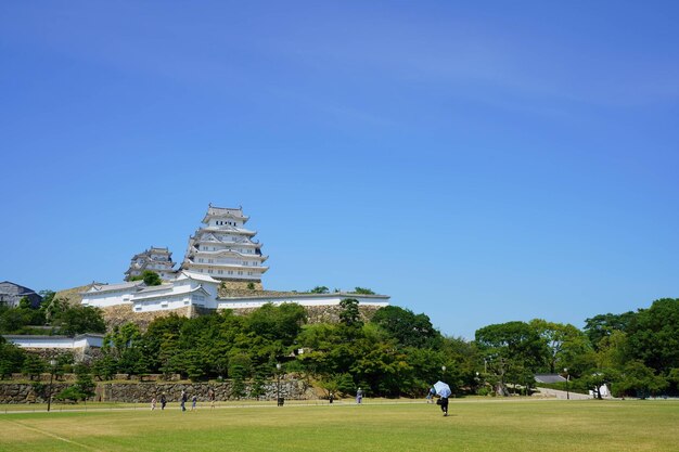 Group of people in front of himeji castle against clear blue sky